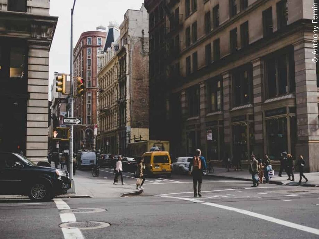 A busy city street, a yellow taxi suggests it is America