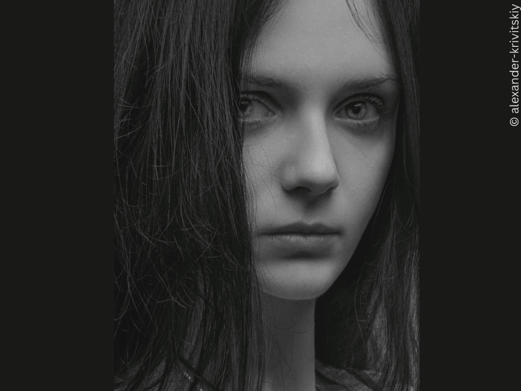 A black and white photograph of a girl looking at the camera.