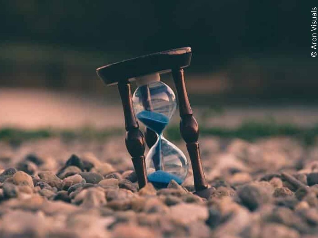 Blue sand running through an egg-timer