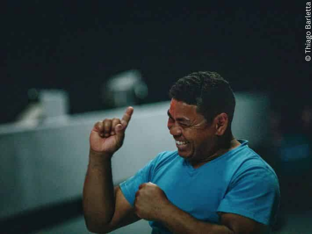 A boy raises a finger while smiling